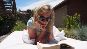 Girl reading book in yard